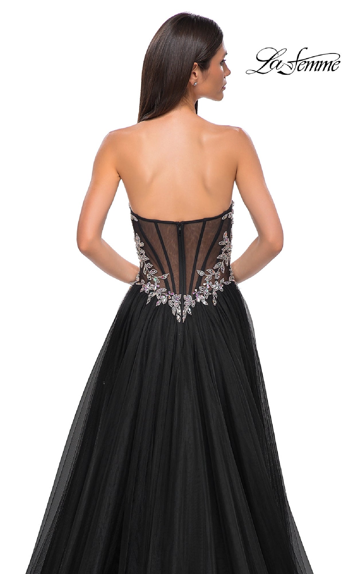A woman faces away from the camera in a Beaded-Corset Strapless Prom Gown: La Femme 32862, featuring a sheer embroidered back panel, against a white background. The La Femme logo appears in the top right corner.
